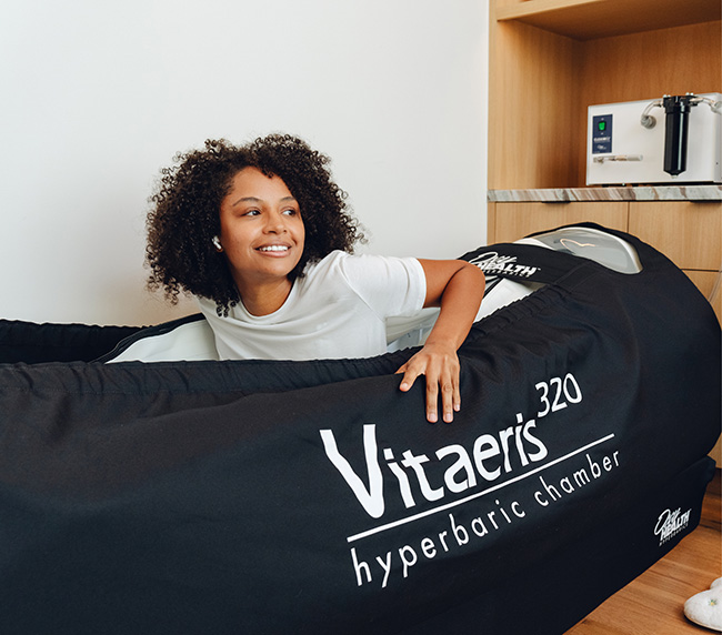 Guest relaxing in an OxyHealth Vitaeris 320 soft-shell hyperbaric chamber